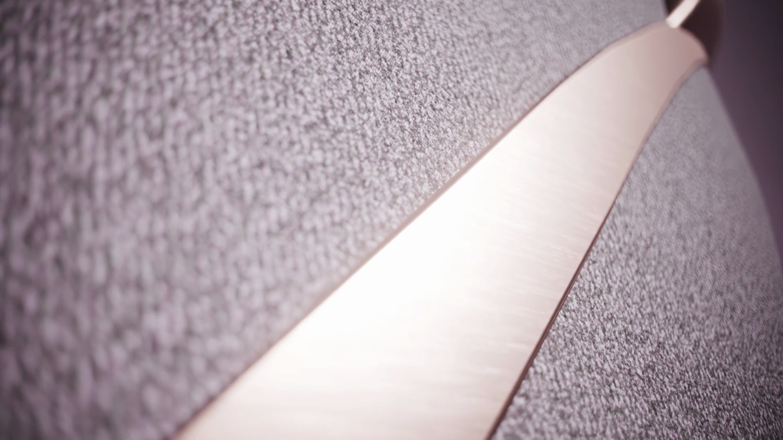 Macro detail of the MinaRosa belt soft textile shell with rose gold piping catching the light